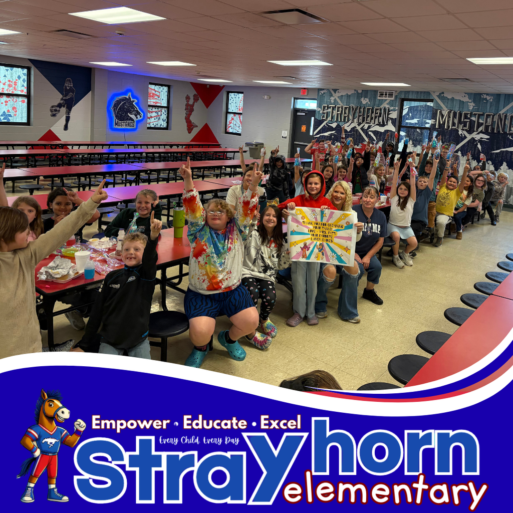 children with lunches smiling at the camera in the cafeteria