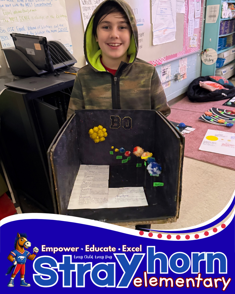 student smiling holding a 3D model of the solar system