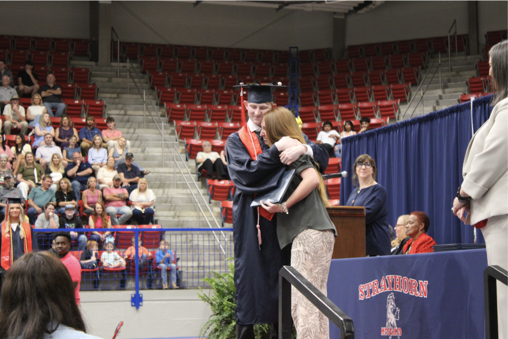 Graduate hugging mom.