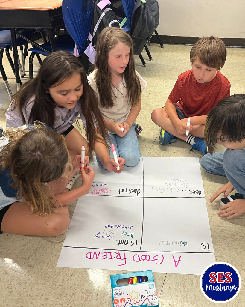 students writing on poster