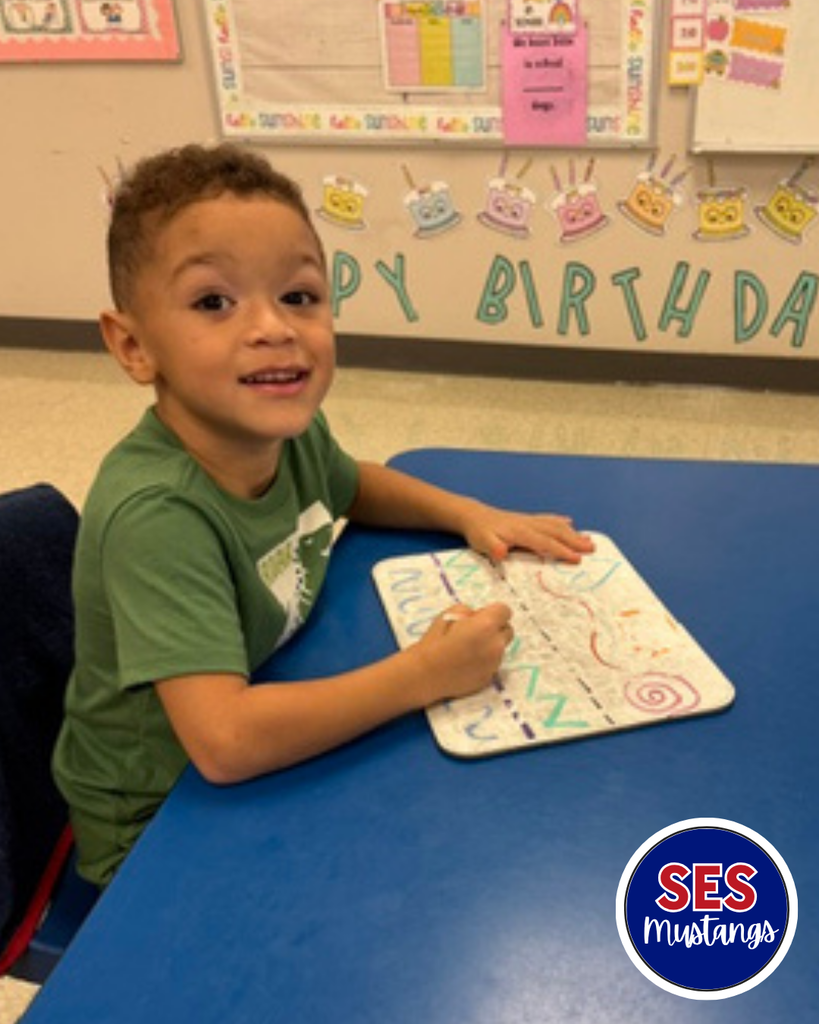 Child with q-tip erasing lines on a whiteboard.