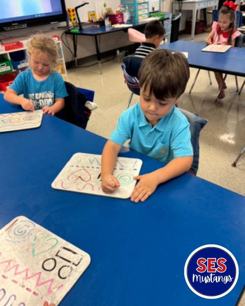 Child with q-tip erasing lines on a whiteboard.