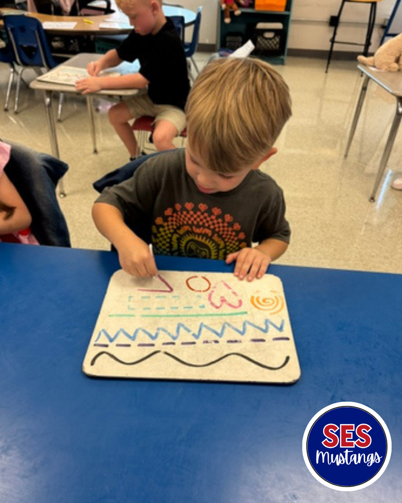 Child with q-tip erasing lines on a whiteboard.