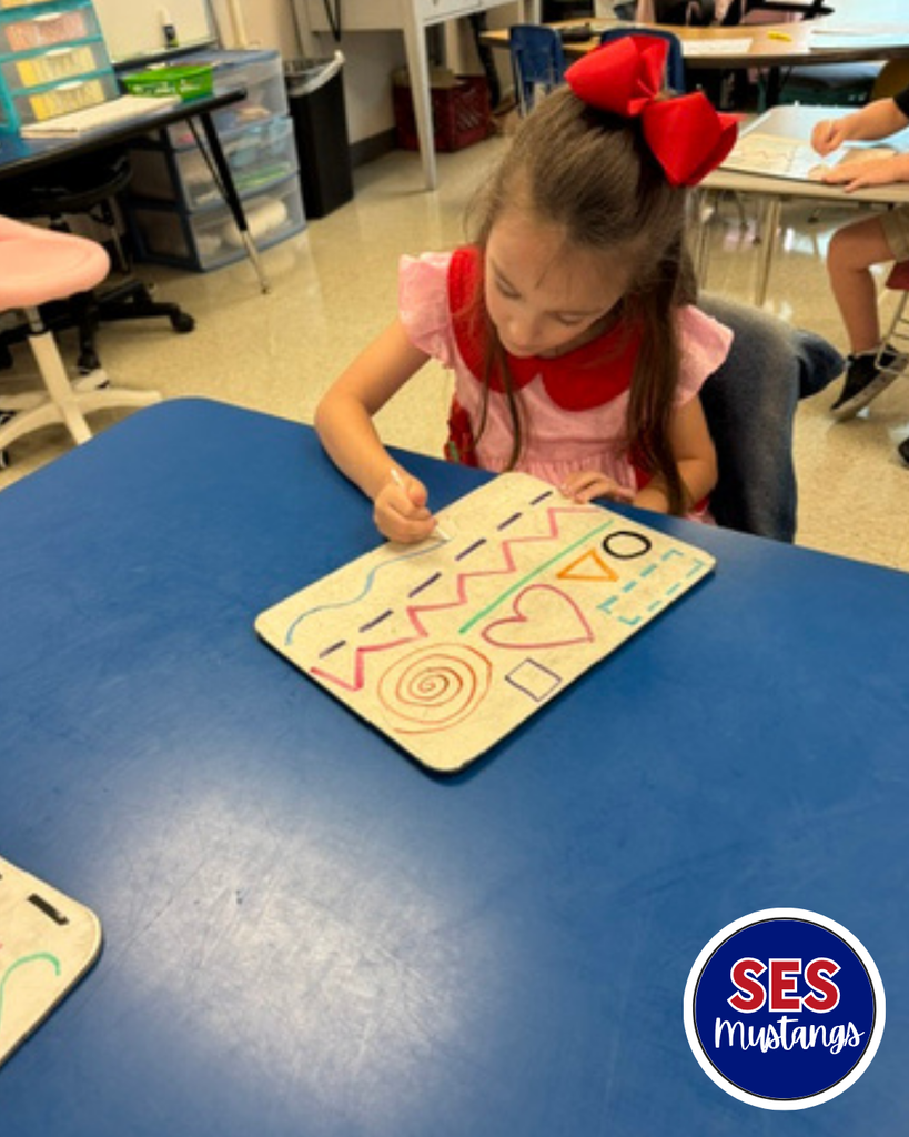 Child with q-tip erasing lines on a whiteboard.