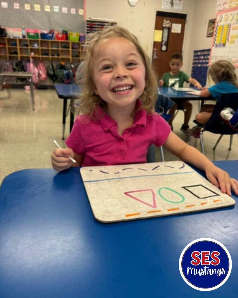 Child with q-tip erasing lines on a whiteboard.