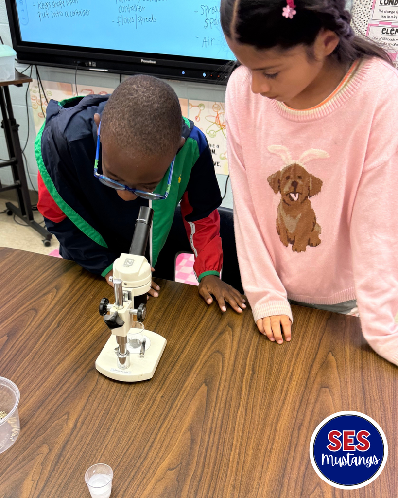 student looking in microscope