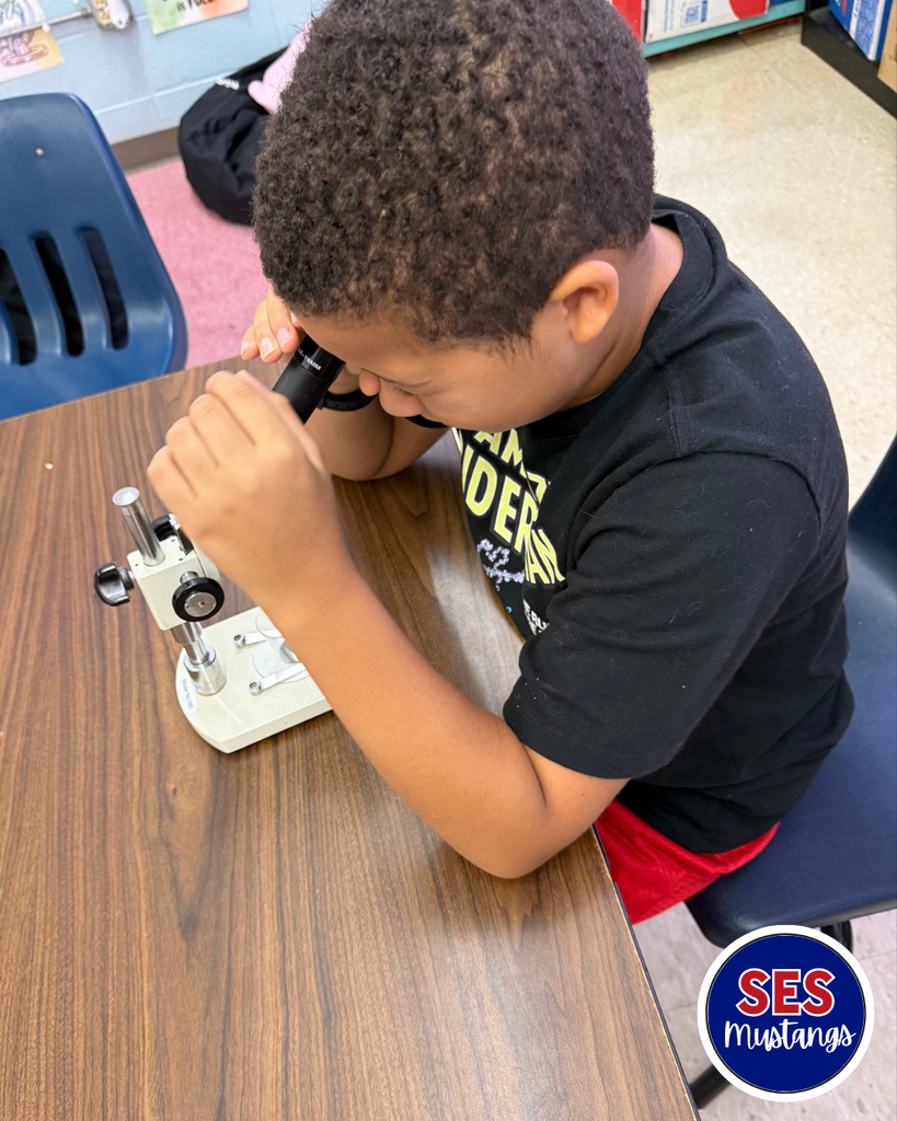 student looking in microscope
