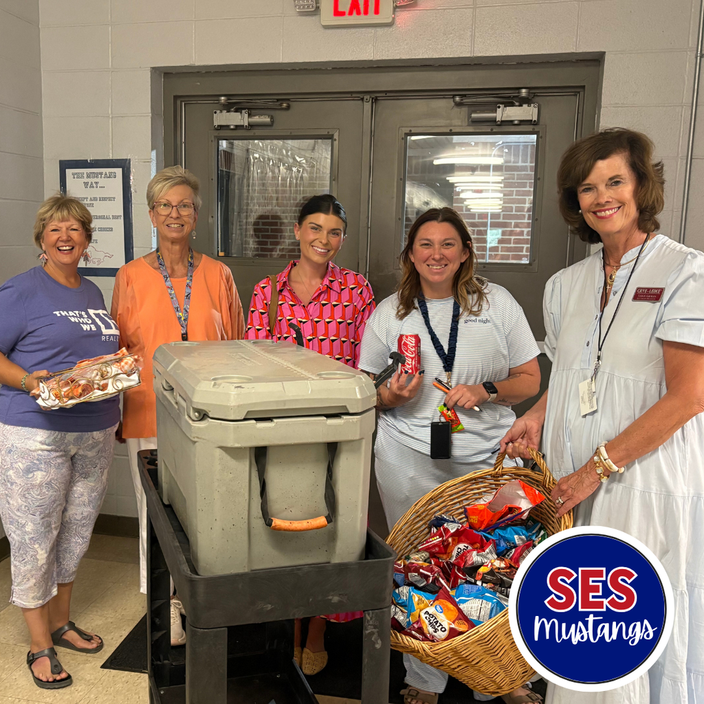 teachers smiling at camera holding snacks