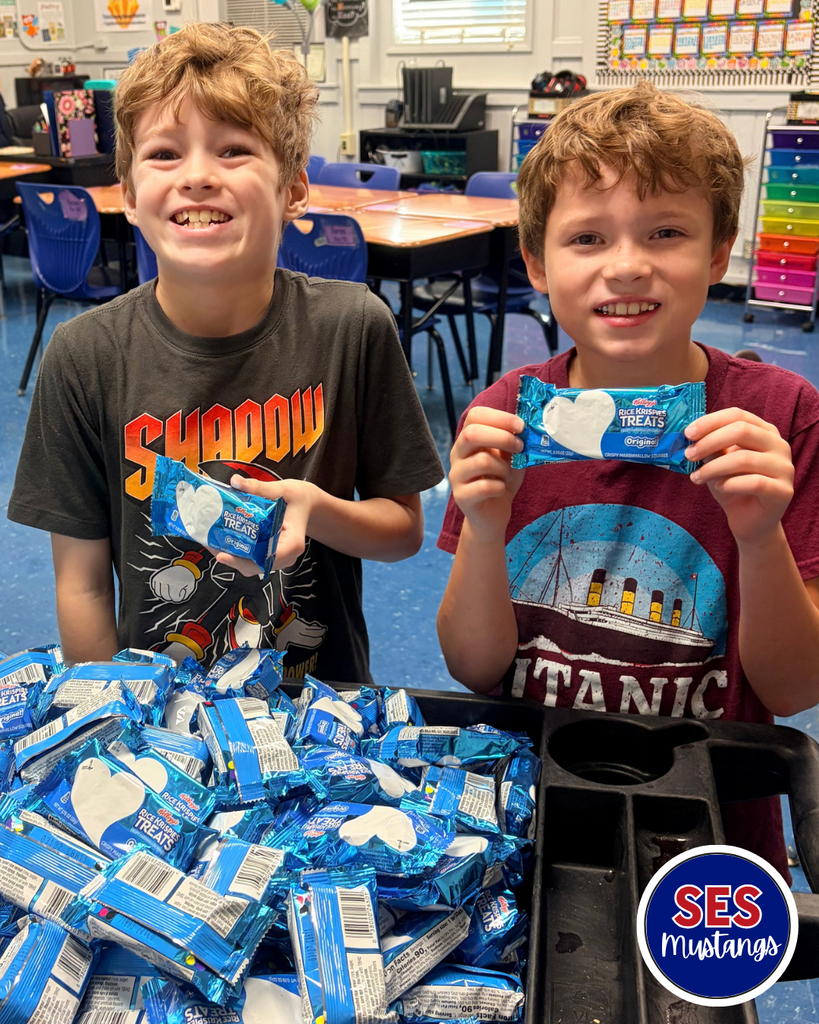 students smiling at camera holding rice krispies treat