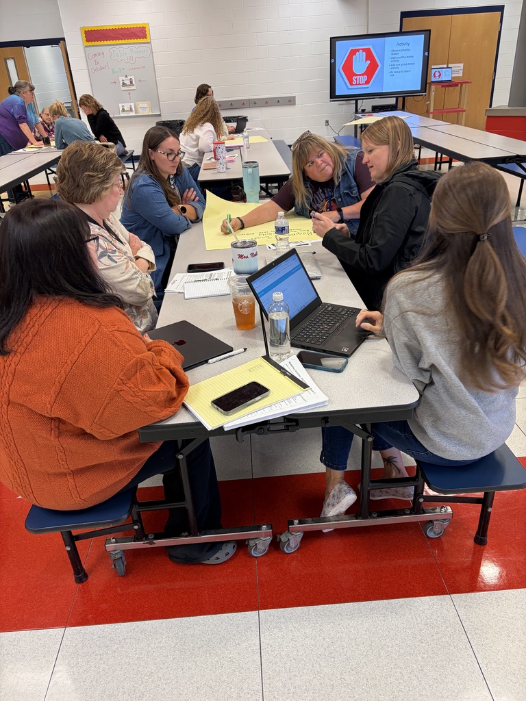Staff sharing ideas and recording thoughts on chart paper