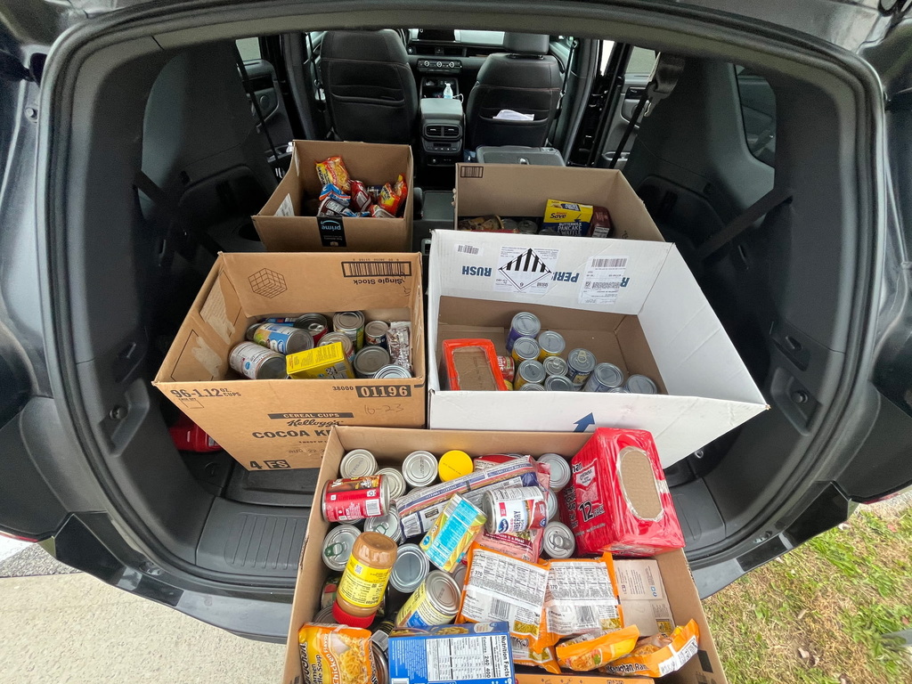 5 boxes of collected food loaded into a car