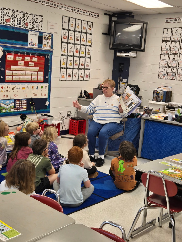 Wynne Proudfoot reading a book to Mrs. Noble’s class