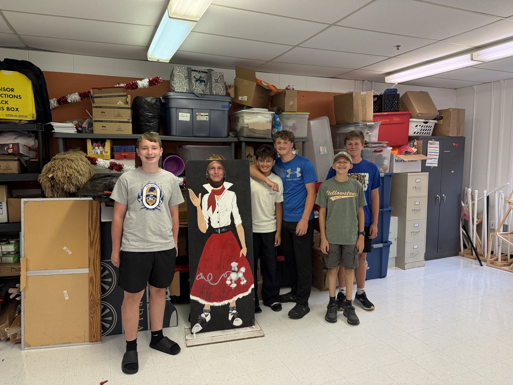 The boys pose in front of the shelves
