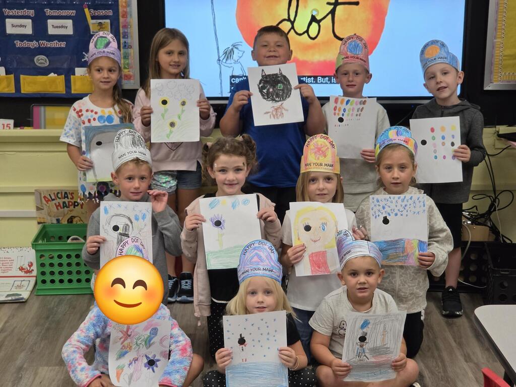 Students pose with pictures.