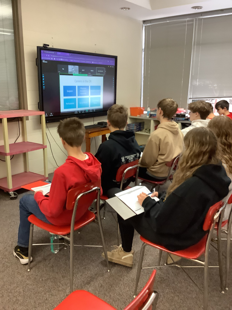 8th grade students viewing procedure in library. 