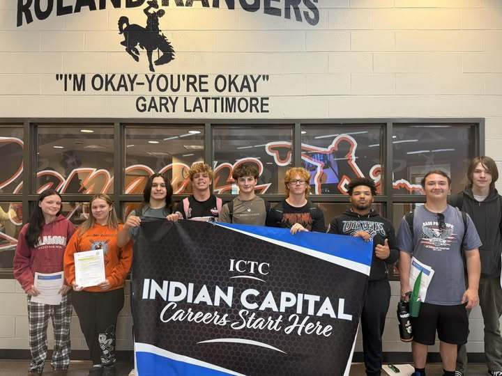 A group of students stands with a banner reading "Indian Capital Careers Start Here" in front of a sign.