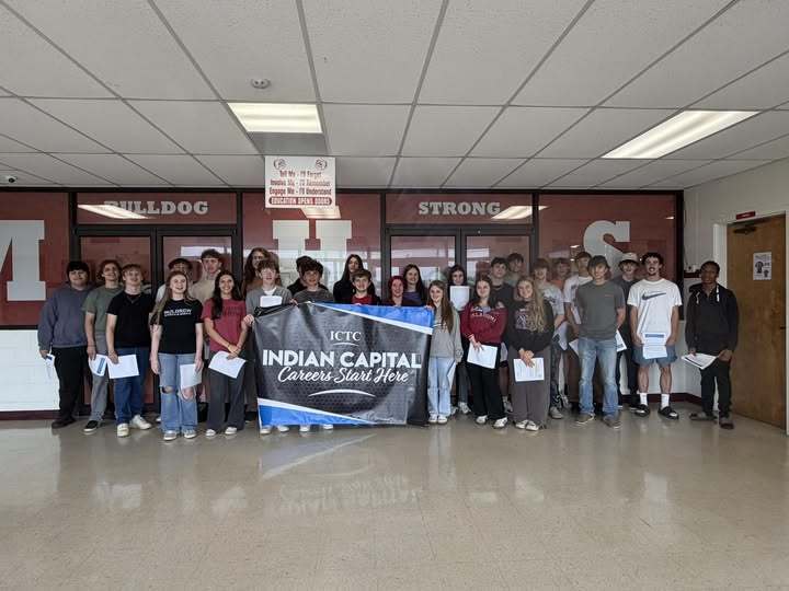 A group of students standing behind a banner that reads "Indian Capital Cancer Care Home".