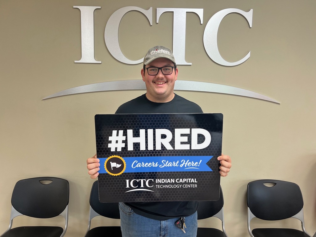 A man in a hat holds a sign that says "#HIRED" in front of the ICTC logo.