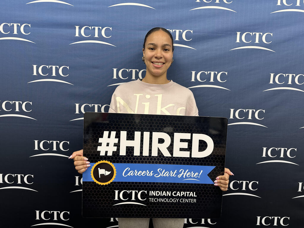 A smiling person stands behind a sign that reads "#HIRED" in bold letters, with "Careers Start Here!" written below it.