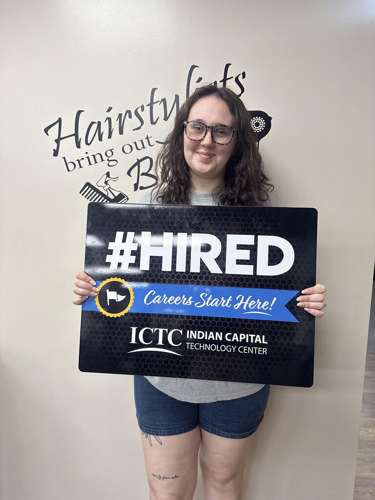 A woman holds a sign that says "#HIRED" and "Careers Start Here!" with a logo for ICTC.