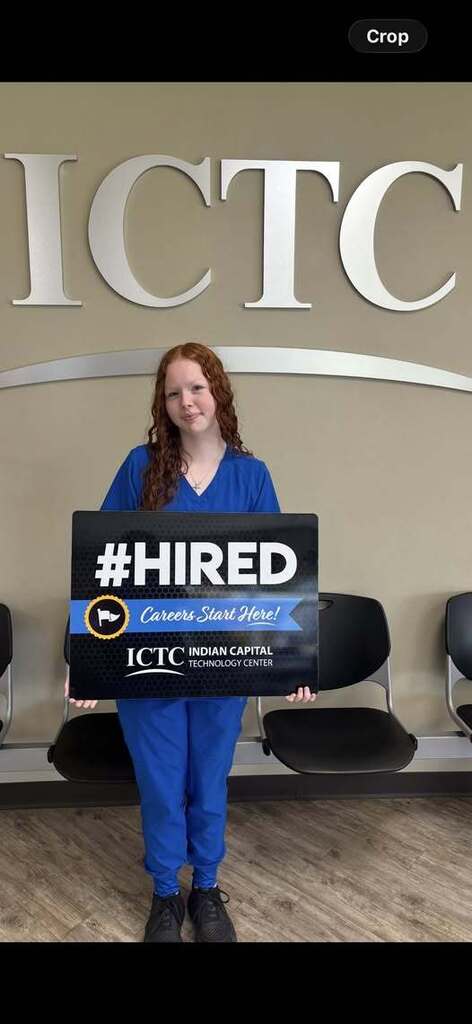 A person in blue uniform holds a sign reading "#HIRED Careers Start Here!" in front of ICTC sign.