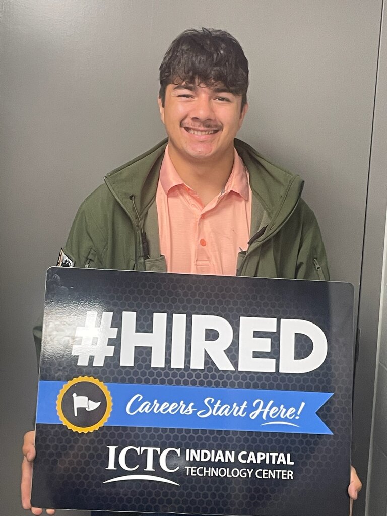 Person holding a sign with a blue ribbon, text reads "#HIRED Careers Start Here!" and "ICTC Indian Capital Technology Center".