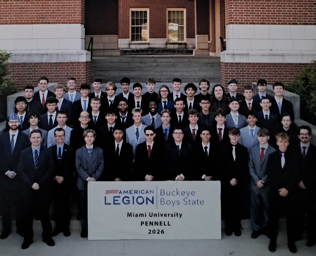 Group of people in suits, standing in front of a sign that reads "American Legion Buckeye Boys State."