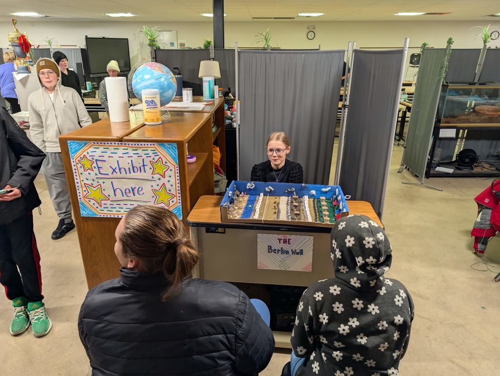 student displaying model of Berlin Wall