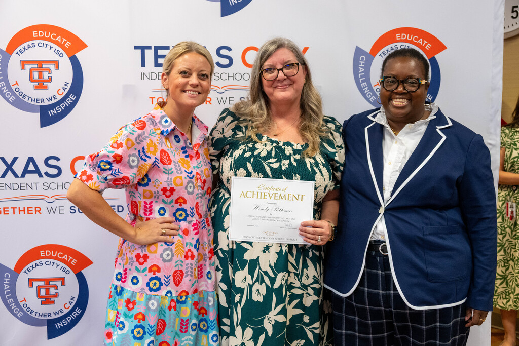 Guajardo Elementary Principal Wendy Patterson receives a certificate from Board President Nakisha Paul.
