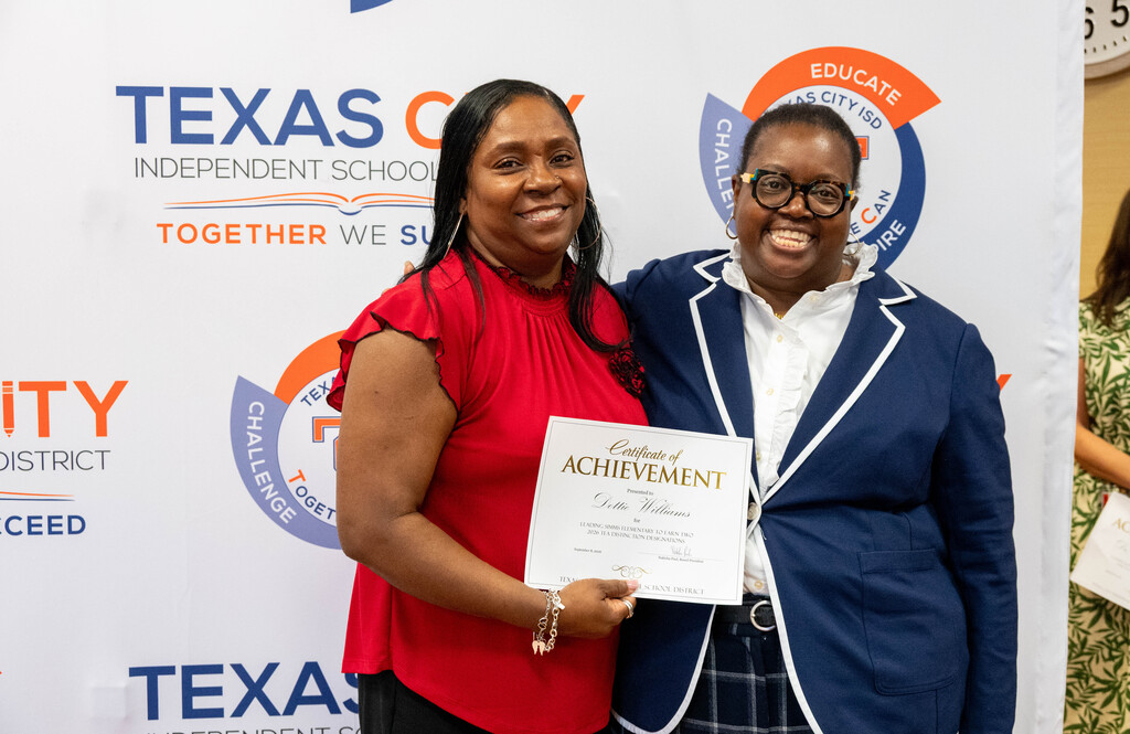 Simms Elementary Principal Dottie Williams receives a certificate from Board President Nakisha Paul.