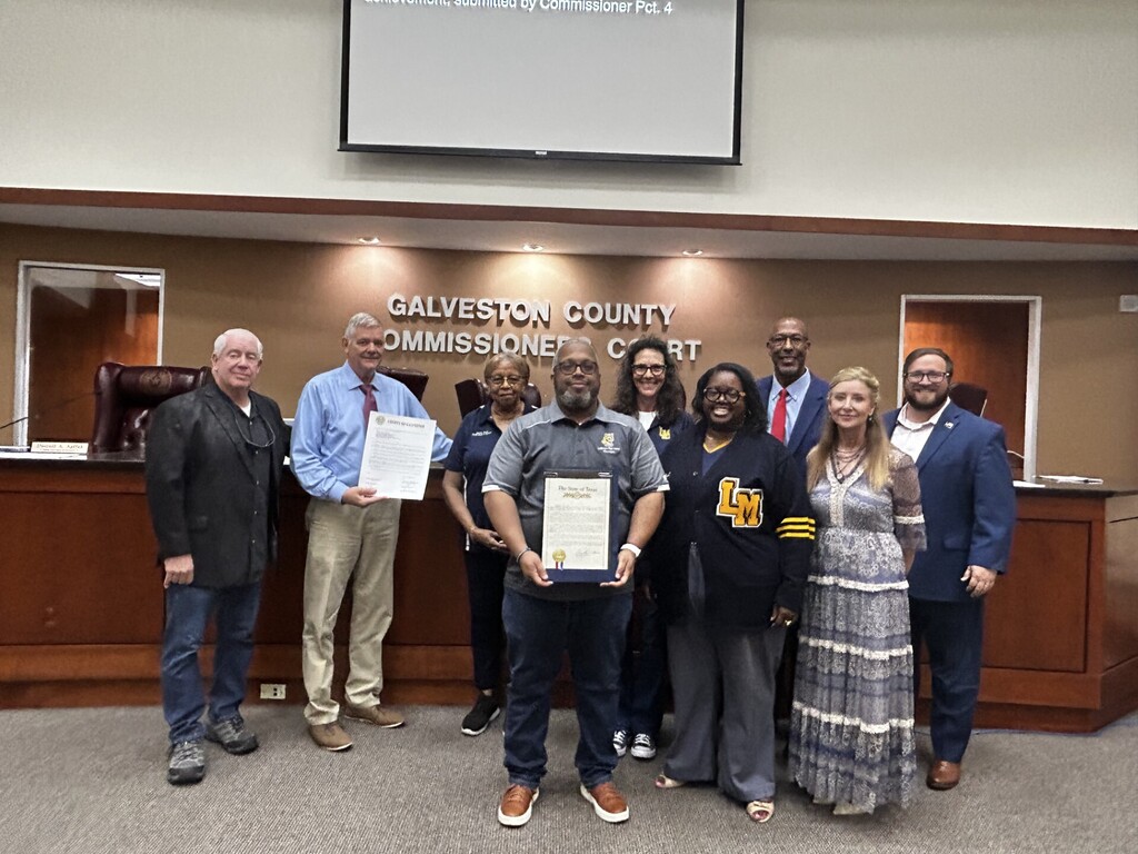 Group photo of County Commissioners, LMHS Principal, TCISD Superintendent, School Board Members and State Rep holiding proclamations in meeting room