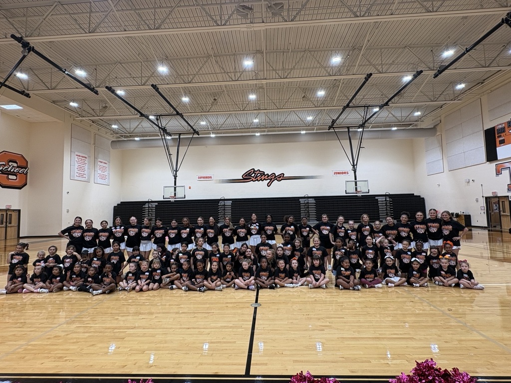 TCHS cheerleaders and cheer clinic participants pose together for a group photo in the gym.