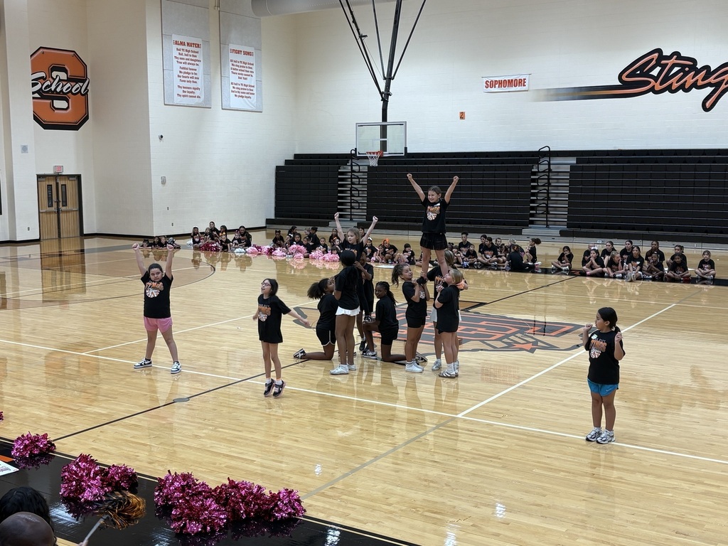 Cheer clinic participants practice a stunt and cheer routine in the TCHS gym.