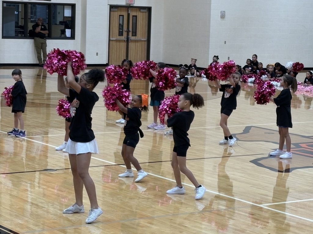 Cheer clinic participants practice a stunt and cheer routine in the TCHS gym.