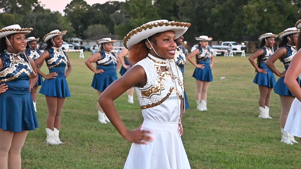 Members of the Cougarettes stand with hands on hips waiting to perform at the pep rally.