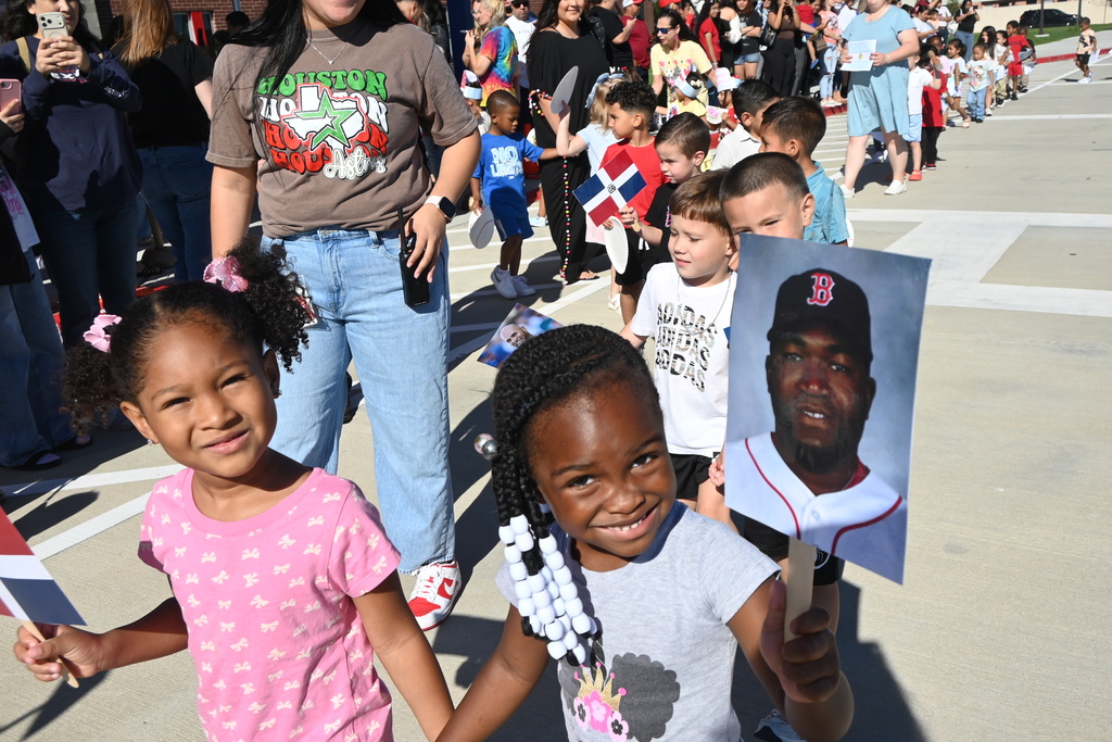 Students holding flags from the Domincan Republic as well as photos of famous professional baseball players from the DR