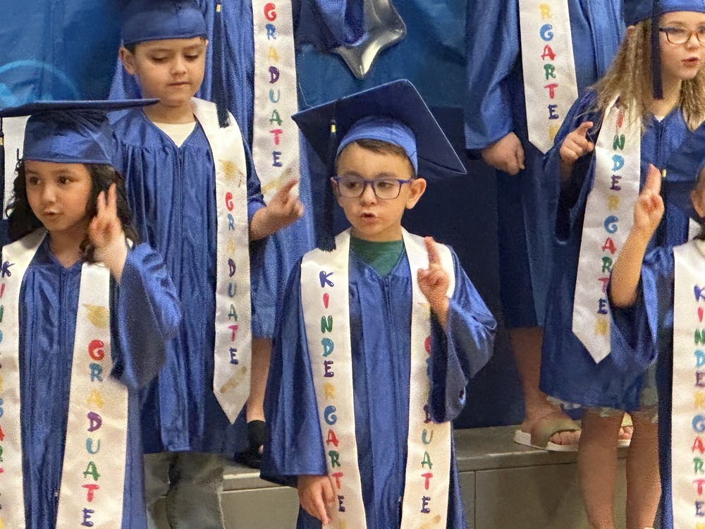 kindergarteners in caps and gowns