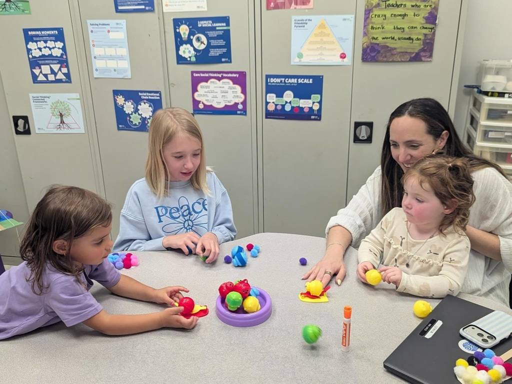 A teacher and students playing on a table