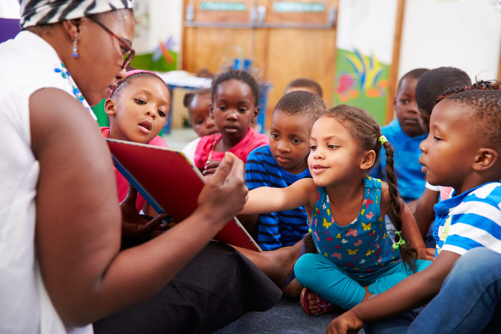 teacher reading a book to children