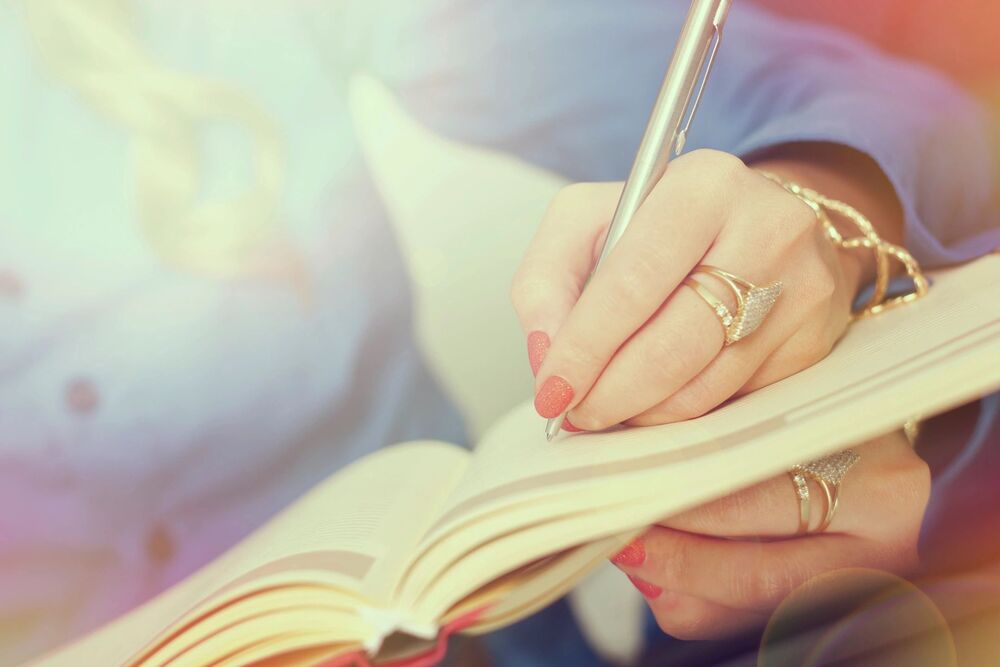 person writing with their left hand