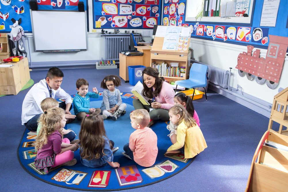 kids and teacher sitting in a circle on the floor