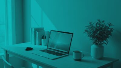 An open laptop sits on a desk next to a coffee mug, a potted plant, and books, styled with a monochromatic teal overlay.