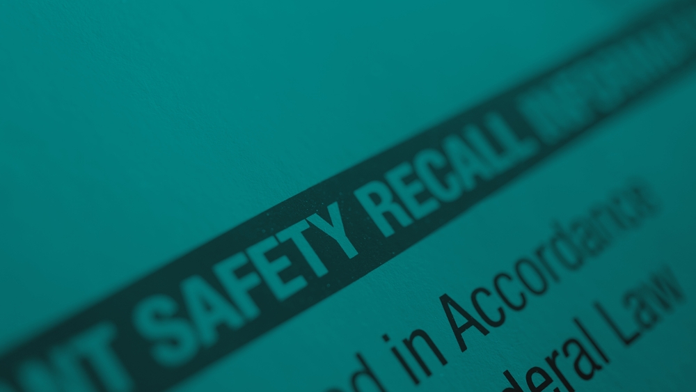 Close-up of a document with the bold heading “SAFETY RECALL,” partially in focus, with smaller text below.