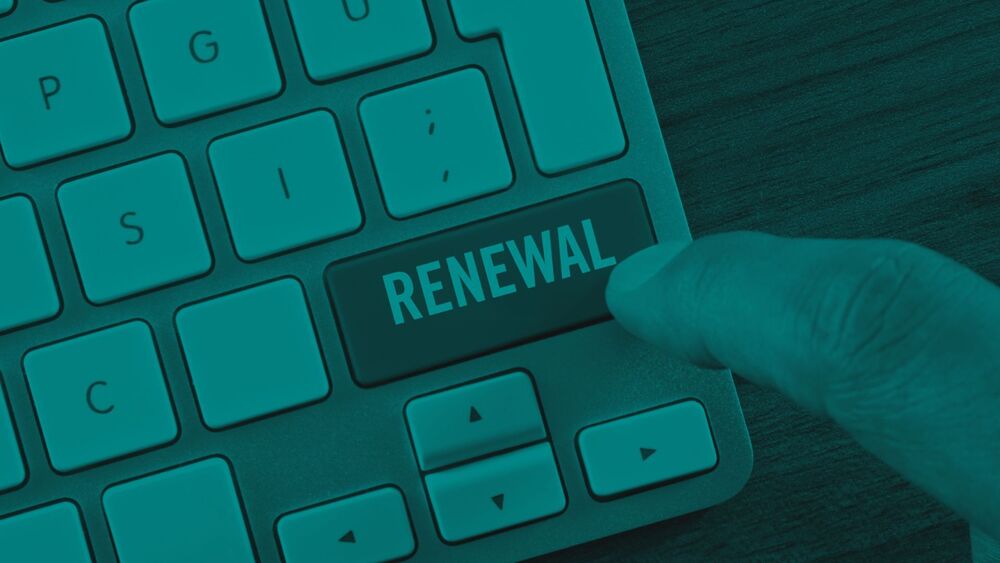 Finger pressing a keyboard key labeled “Renewal” on a computer keyboard.
