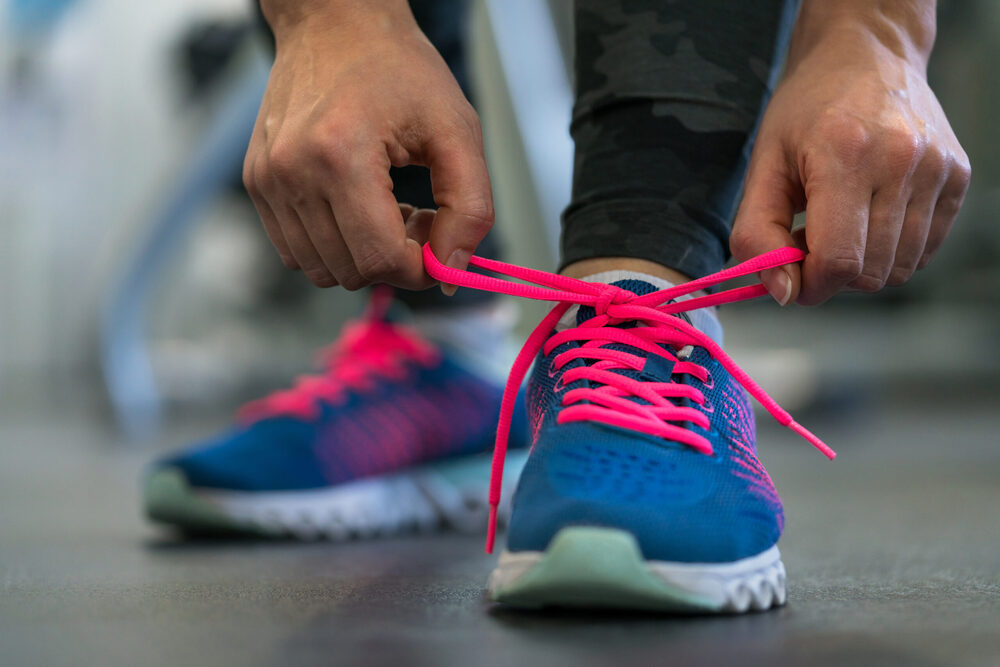 person tying up running shoes