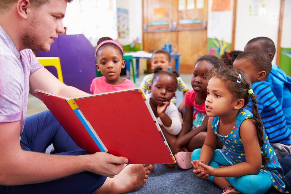 teacher reading a book to children