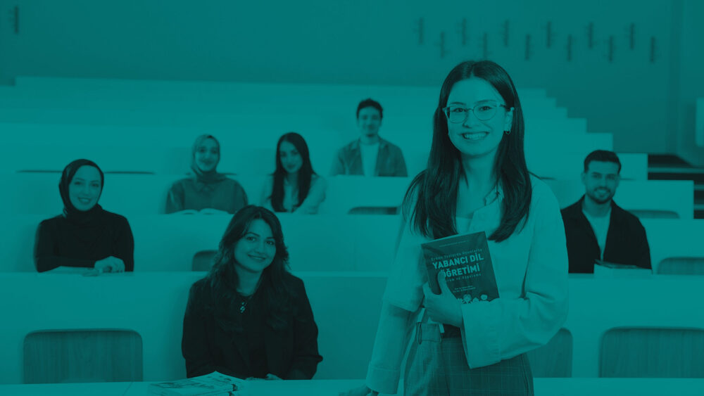 A smiling woman with glasses holds a textbook in a tiered lecture hall with students behind her, styled with a monochromatic teal overlay.