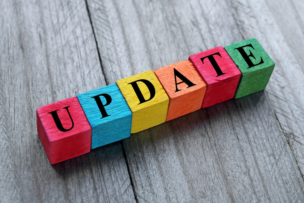 Colorful wooden blocks spelling out the word UPDATE on a wooden surface
