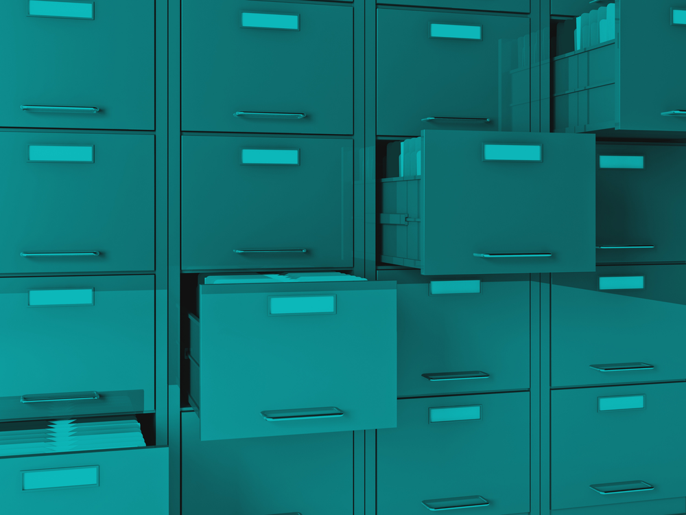 Opened teal filing cabinet drawers filled with file folders.