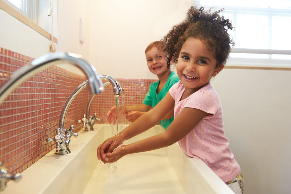 two kids washing their hands